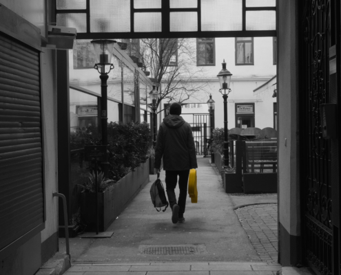 Schwarz-/Weiß-Bild mit Person und einem gelebn Gitarrenkoffer