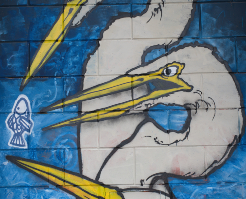 Grafiti mit 3 weißen Vögeln welche alle einen Fisch wollen