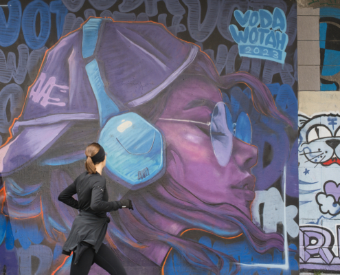 Joggerin beim laufen mit Blick auf Grafiti