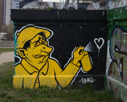 Gelb-schwarzes Grafit: Mann mit zweifelnden Blick sprüht ein Herz