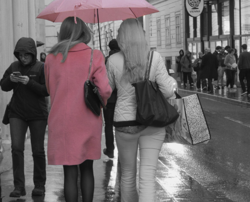 Schwarz-Weiß Bild mit 2 Frauen von hinten mit Rosa Regenschirm und Rosa Jacke