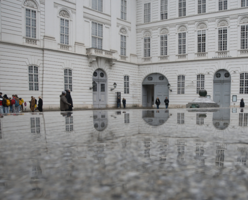 Spiegelung von Haus und Personen am Josefplatz
