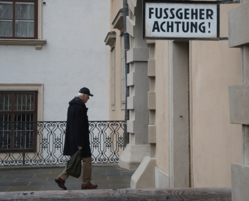"Fussgeher Achtung!"-Schild mit älterem Herrn