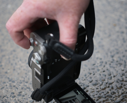 Hand und Kamera von Christian Mari - Fototrainer wie er den Theseustempel bodennahe fotografiert